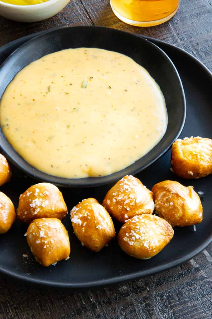 small pretzels next to a big bowl o cheese sauce
