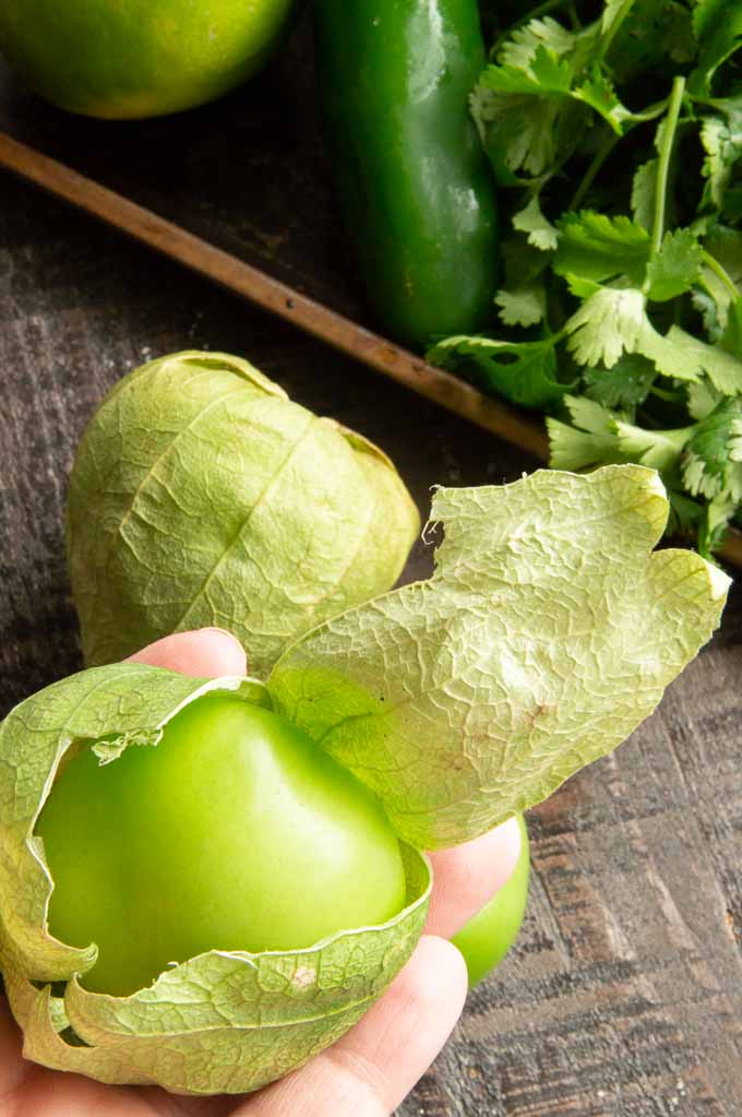 peeling the skin off of tomatillos