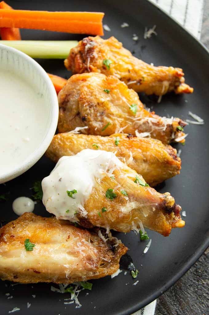 Crispy CHicken wings with garlic parmesan sauce on a plate