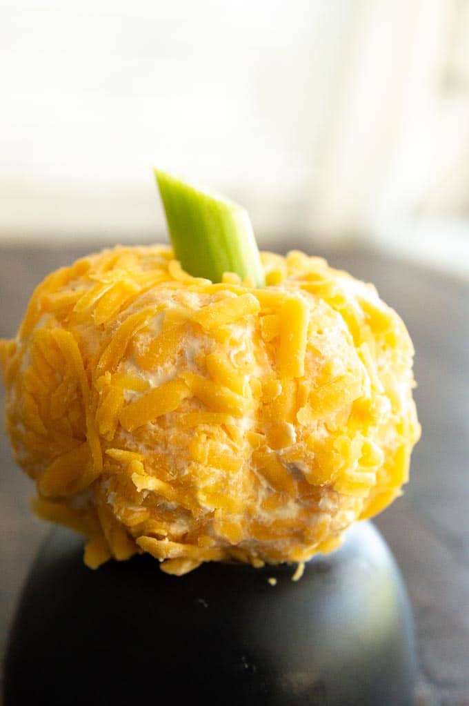 Pumpkin Shaped CHeeseball on a black plate