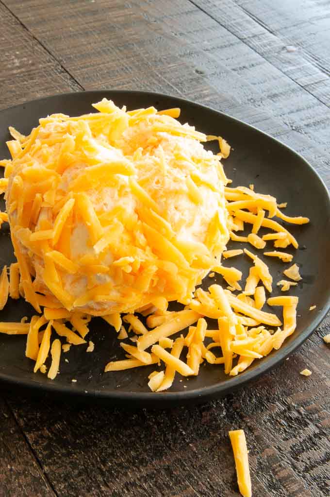 rolling the pumpkin ball in shredded cheese