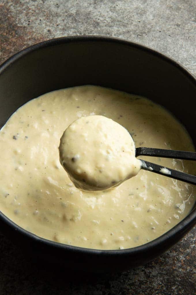 black bowl of horseradish sauce being spooned out