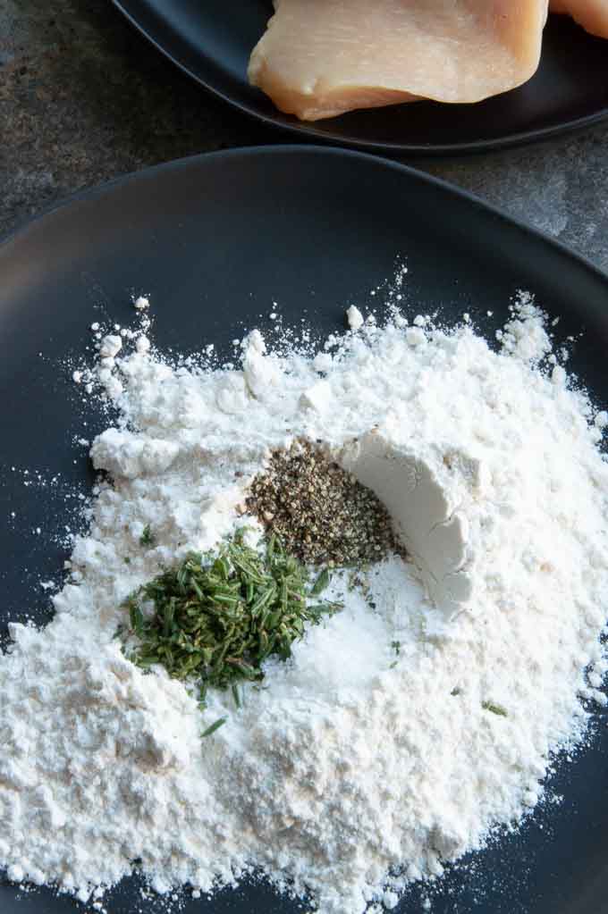 Seasoning the flour for mustard chicken saute