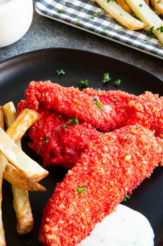 air fried flamin hot cheetos coated chicken on a plate with fries