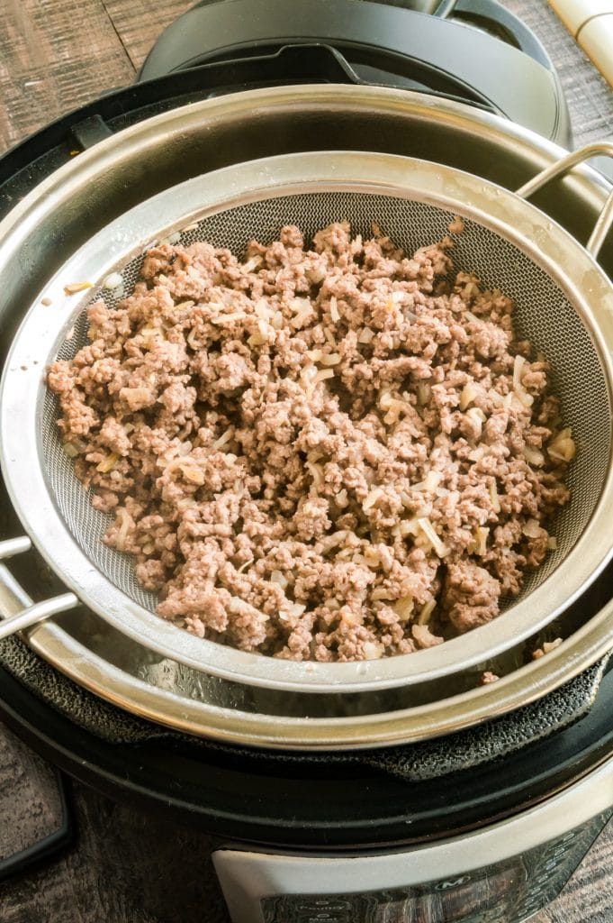 straining the fat away from the ground beef
