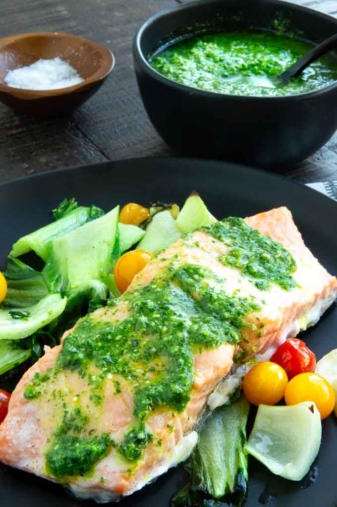 bowl of pesto being served next to the salmon on a dinner plate