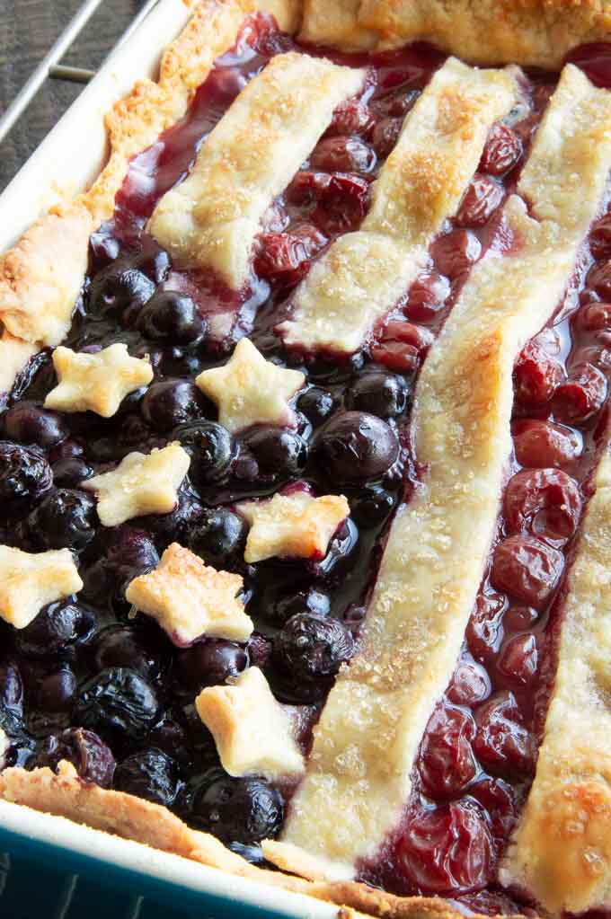 closeup of baked stars, strips on top of cherry pie fillig