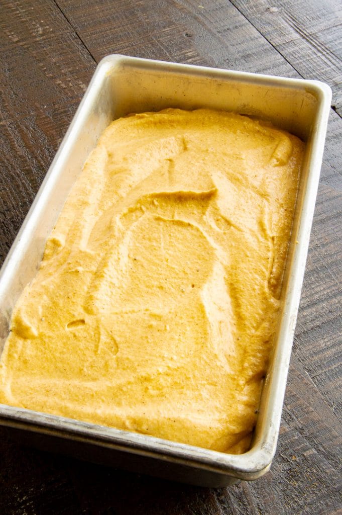pumpkin ice cream placed in a metal loaf pan for freezing