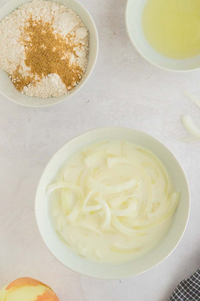 Soaking onions in milk in a white bowl