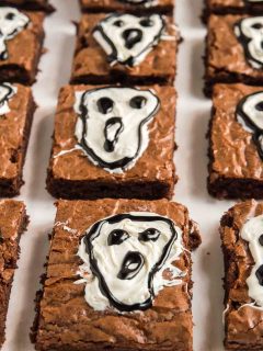brownie squares with ghosts screaming on them on a tray