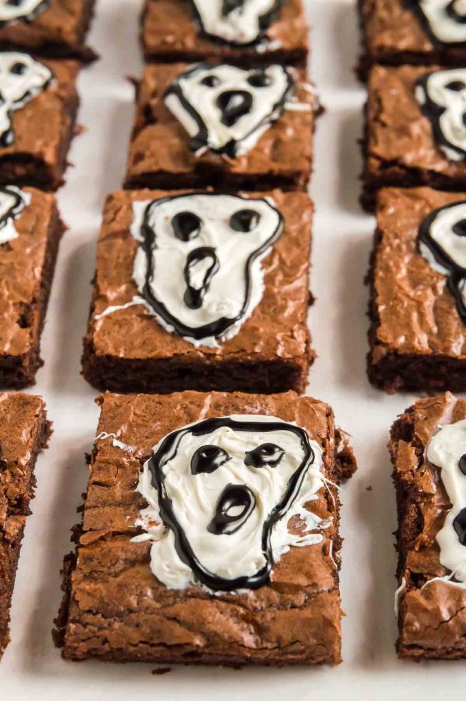 brownie squares with ghosts screaming on them on a tray