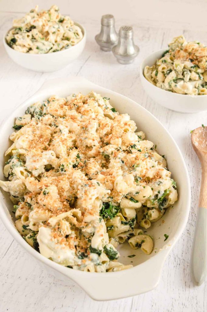 serving bowl of mac and cheese with artichokes and spinach