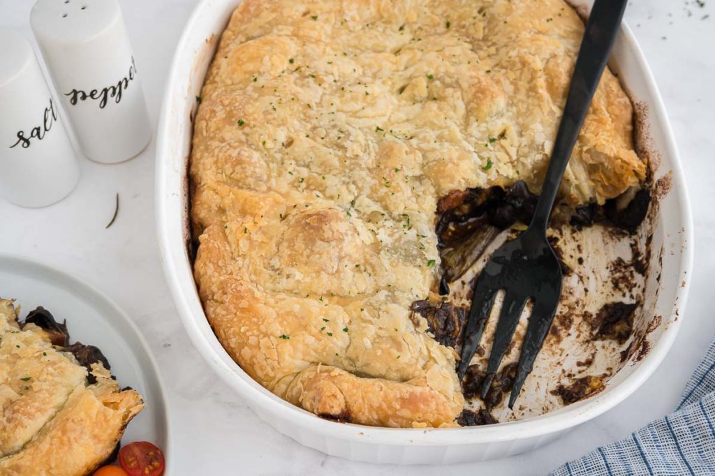 scooping out one piece of beer braised meat with puff pastry topping