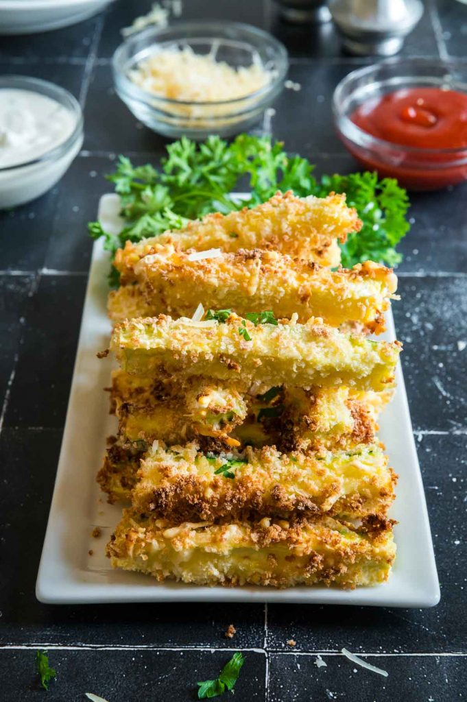 serving tray of stacked zucchini fries next to dipping sauces