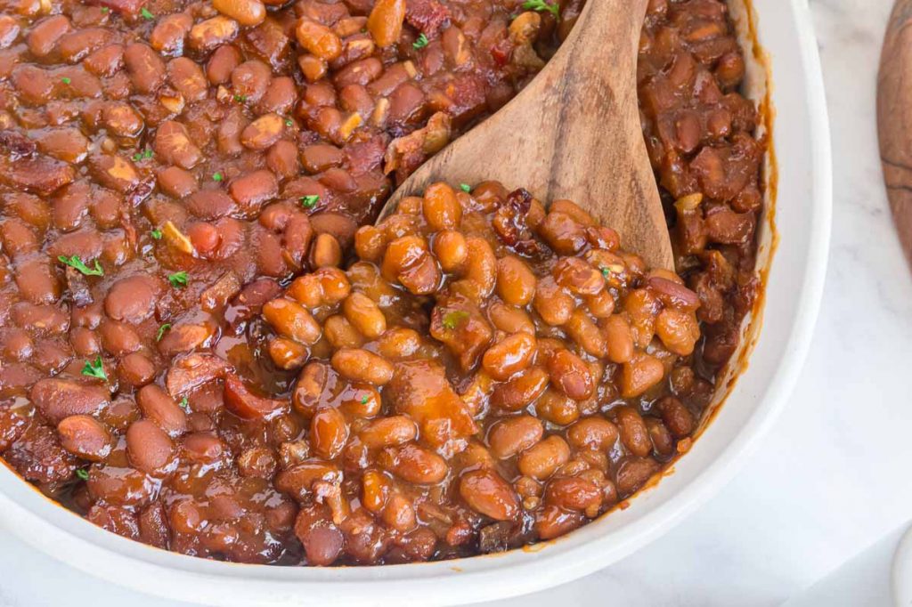 serving dish of baked beans from a can that are doctored