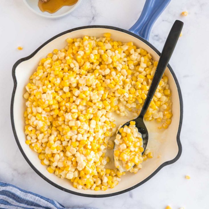 cast iron pan full of honey butter corn