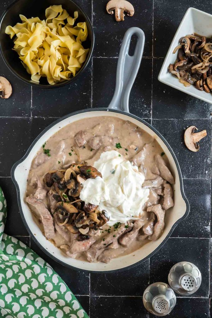 vegetables, meat slices and sour cream in a skillet