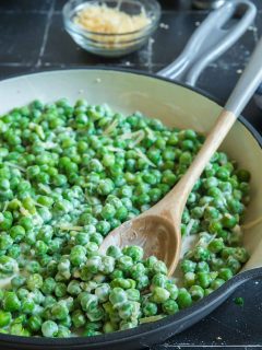 Scooping out honey butter peas from the skillet
