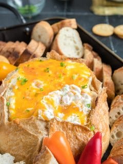 Mississippi Sin dip on a tray with bread, crackers and veggies