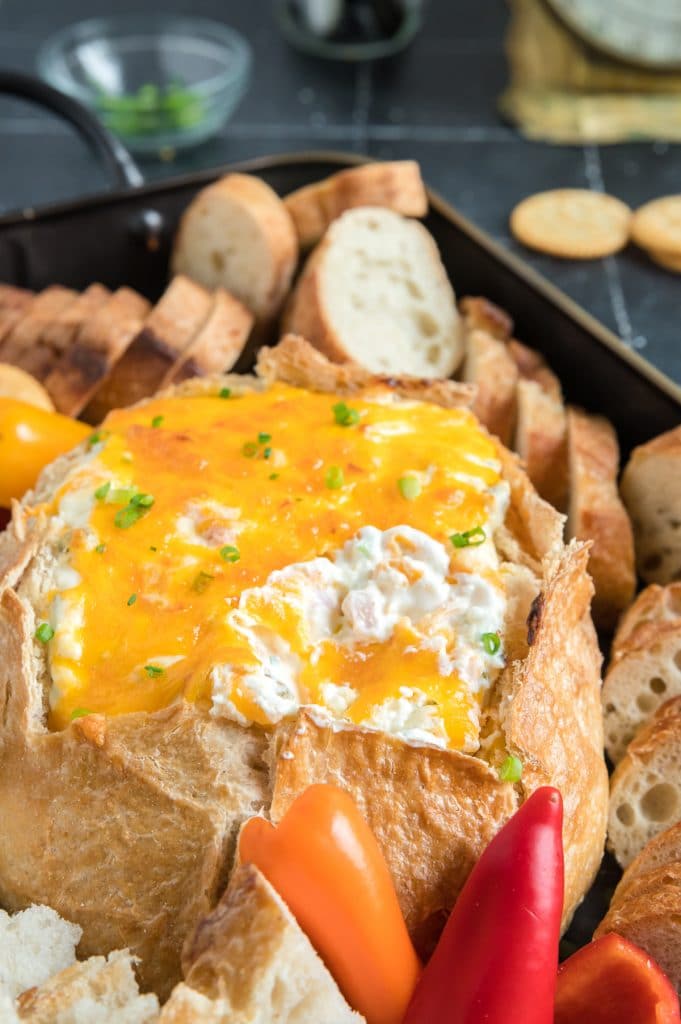 Mississippi Sin dip on a tray with bread, crackers and veggies